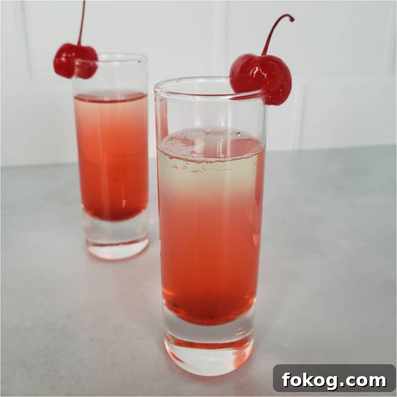 24+ Tropical Pineapple Juice Cocktail Recipes 4 layered red cocktail garnished with cherries