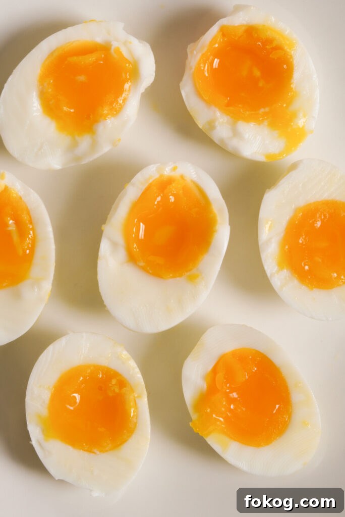 How to Make Soft-Boiled Eggs in an Air Fryer 9 plate of soft boiled eggs cut in half on a plate