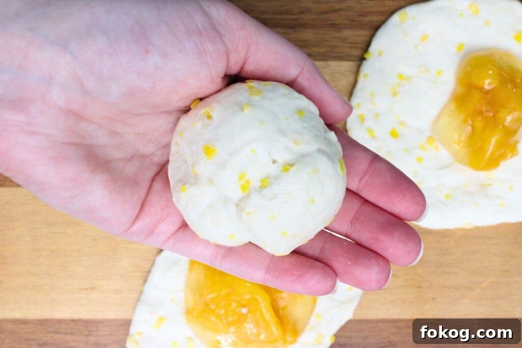 Air Fryer Peach Pie Biscuit Bombs - Quick Dessert 7 close dough around peach pie filling by forming a ball