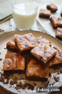 cream cheese brownies on a plate with a glass of milk