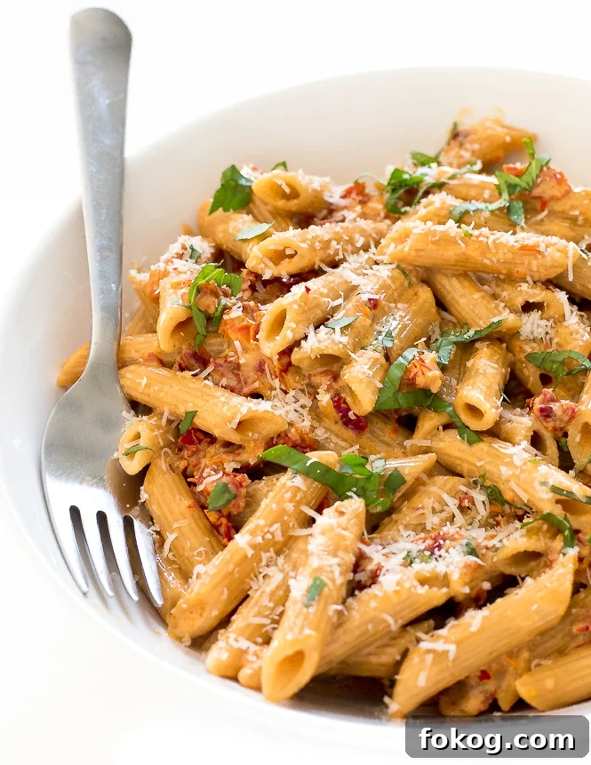 Pasta in a white bowl with a fork. 