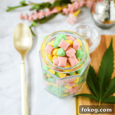How to Make Cannabis-Infused Cupcakes from Cake Mix 13 A white counter top with a gold spoon and a glass jar filled with cannabis butter mints.