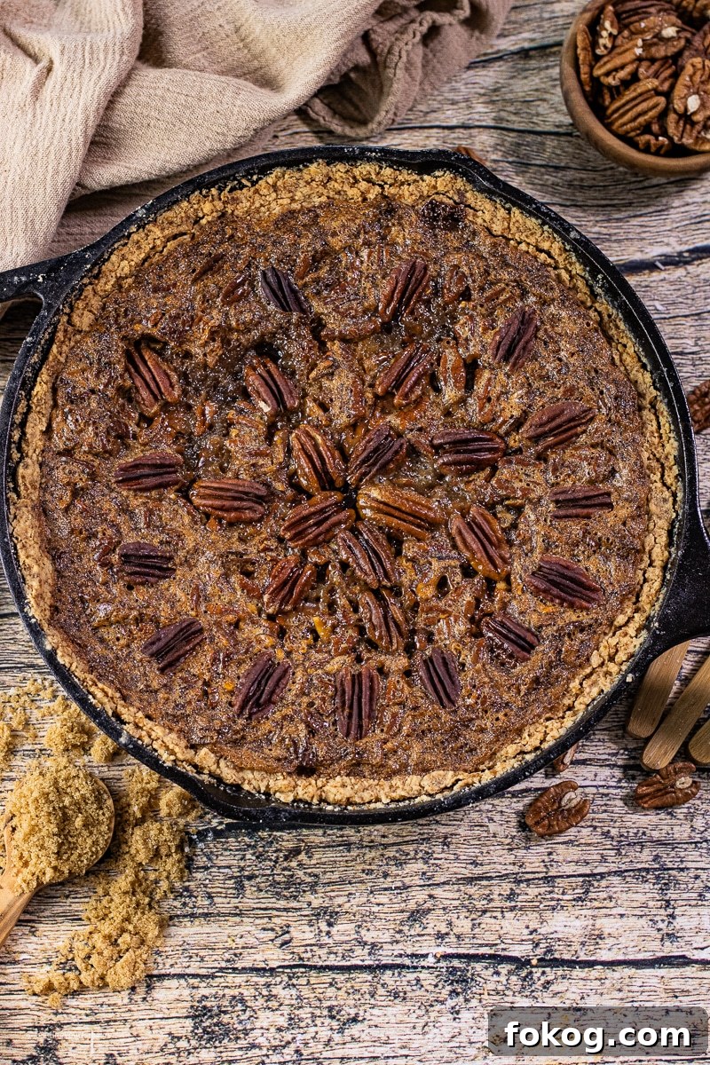 pecan pie baked in a cast iron skillet with pecans on top